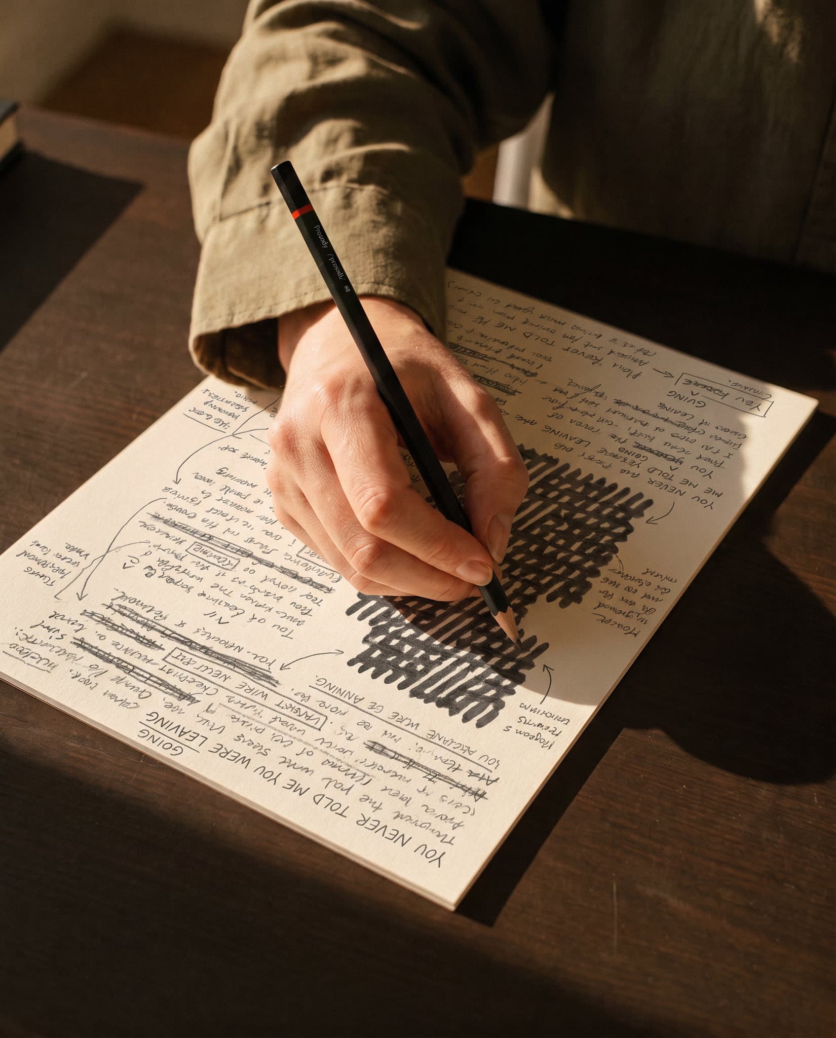 Crayon marqué Prosody, main qui écrit sur une feuille de notes